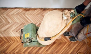 Utilizzando una macchina per la pulizia a secco che sfrutta una miscela di polveri abrasive e una spazzola rotante per rimuovere lo sporco e le macchie dalle superficie del parquet
